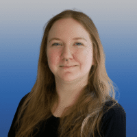 photo of a woman with long blonde hair and blue eyes with a nose ring wearing a black long sleeved shirt and smiling