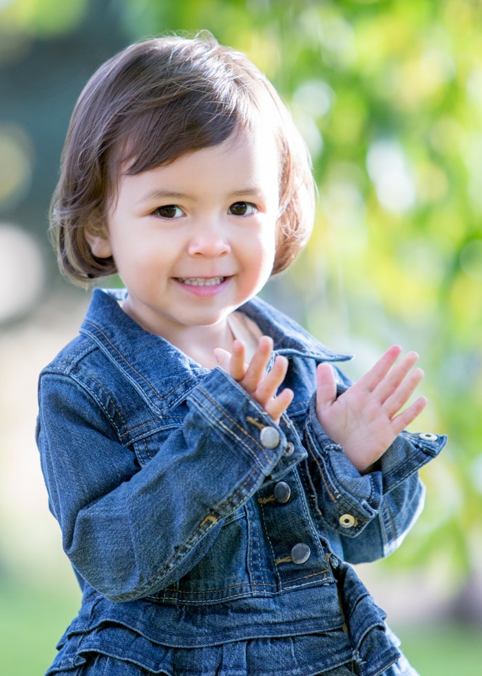 Avy Photo Photo of young girl with brown hair and brown eyes wearing a blue denim dress.